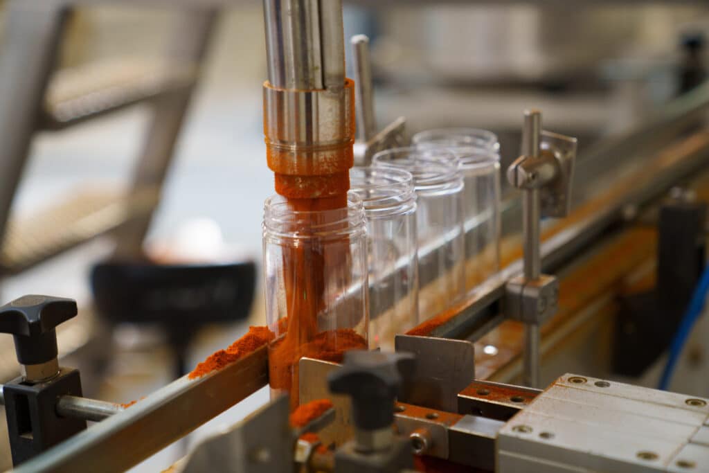 maskine som fylder krydderierne i glas